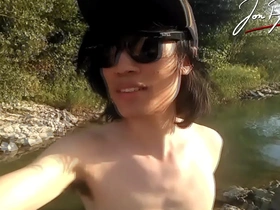Jon Arteen is a slim Asian twink who performs a musical strip-tease while standing in a river with a smile on his face.