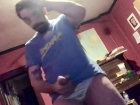 A muscular man with a massive penis pleasures himself alone, clad in satin underwear on his substantial member